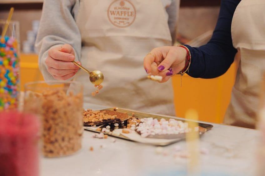 A person wearing a waffle apron preparing food, with a bowl of ingredients and a spoon on the table. 2