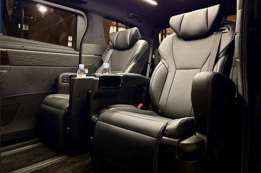 A luxurious car interior with leather seats, a center console, and a rearview mirror. 3