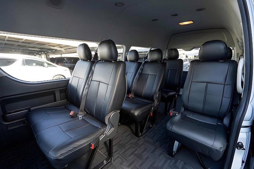 A vehicle interior with black leather seats and a visible seatbelt. 2