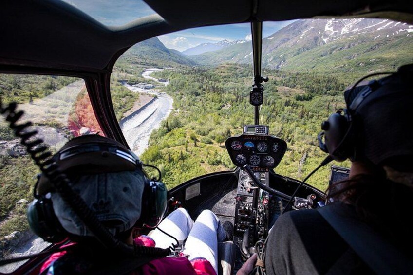 A helicopter cockpit with a mountainous landscape outside. 2
