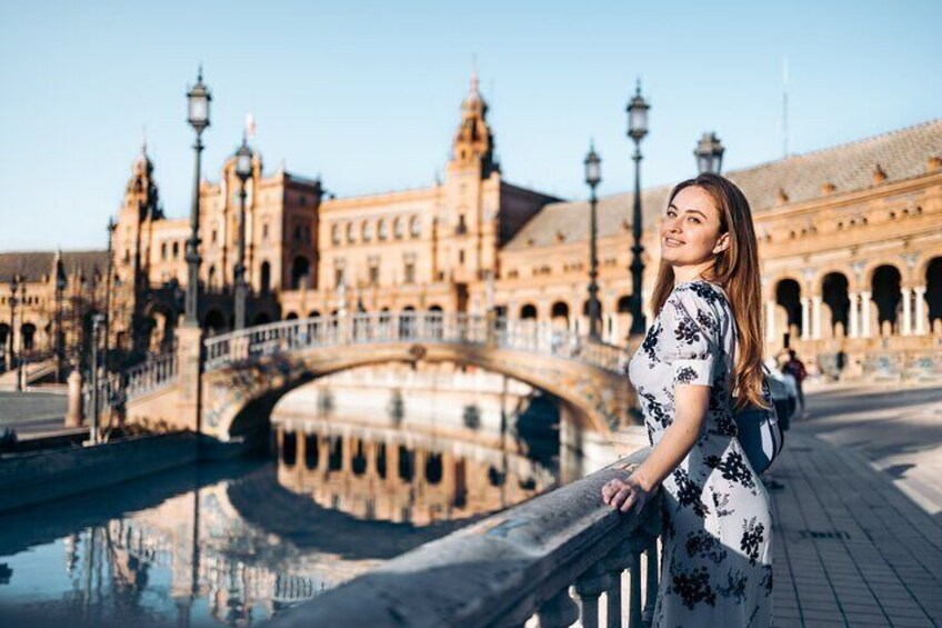 Une femme se tient près d’un pont, avec un bâtiment historique en arrière-plan. 3