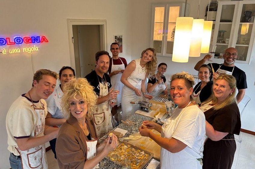 A group of people in a kitchen, some wearing aprons, preparing food. 5