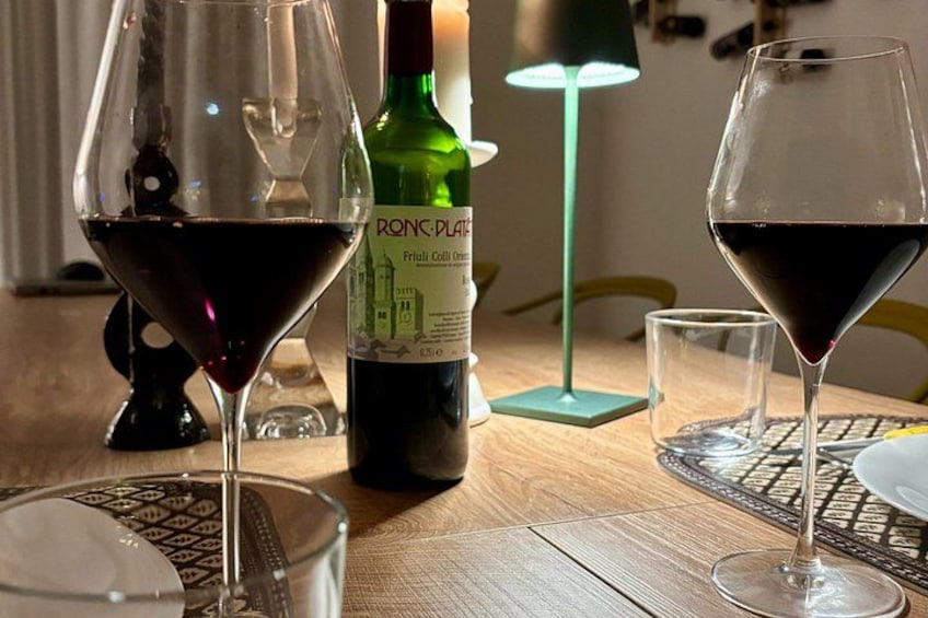 A table with two wine glasses, a bottle of wine, and a candle. 4