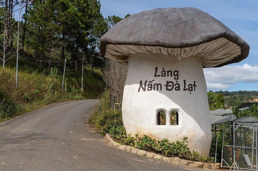 A mushroom-shaped structure with text, a road, and greenery. 3