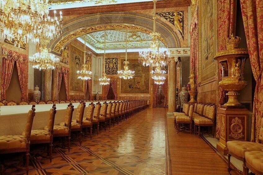 An opulent hall with ornate chandeliers, golden chairs, and detailed wall decorations. 3