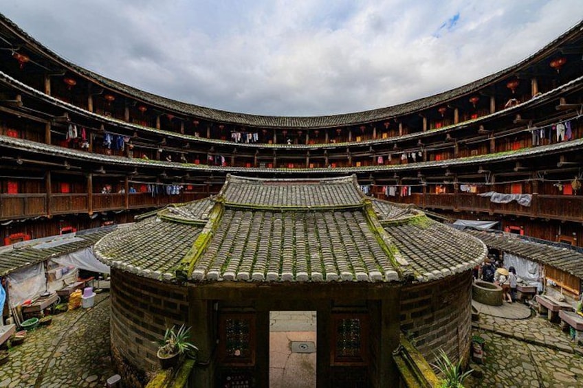 A traditional Chinese courtyard theater with tiered seating and a central stage. 1
