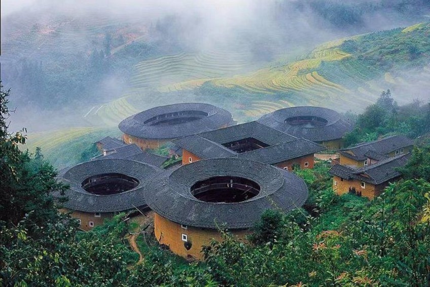Traditional round-roofed buildings nestled in a lush, terraced landscape. 4