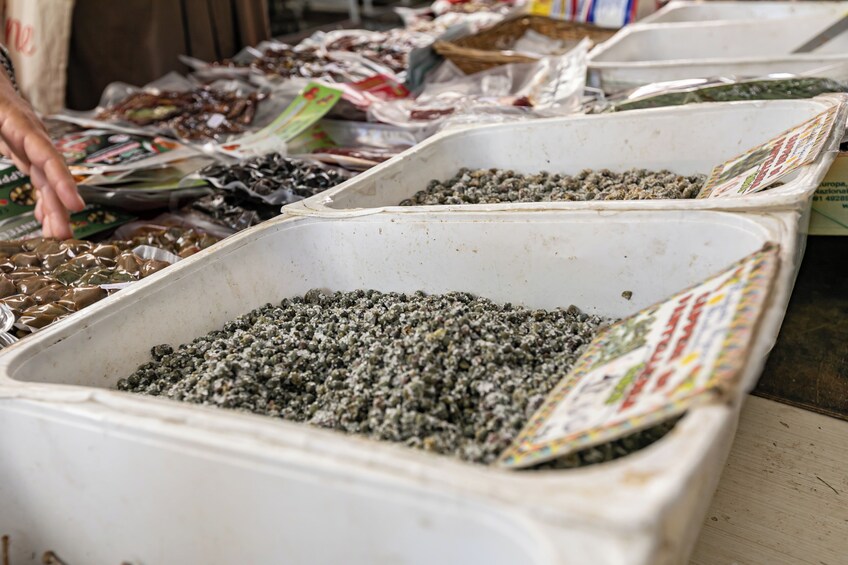Containers filled with various dried goods, likely at a market stall. 3
