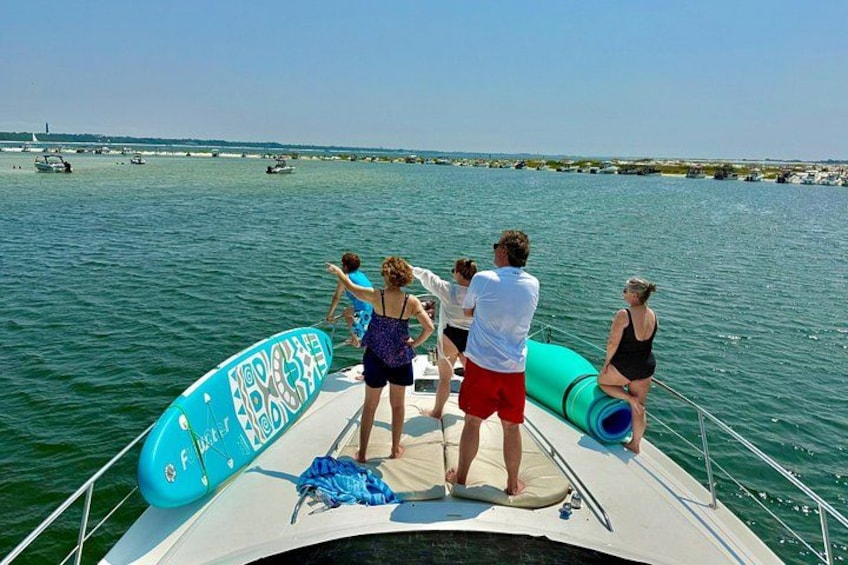 A group of people on a boat with a surfboard and a life preserver. 4