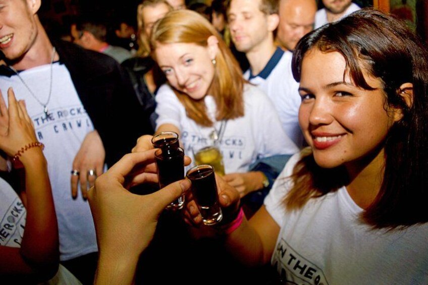 People holding drinks, wearing casual clothing, and a white t-shirt with text. 3