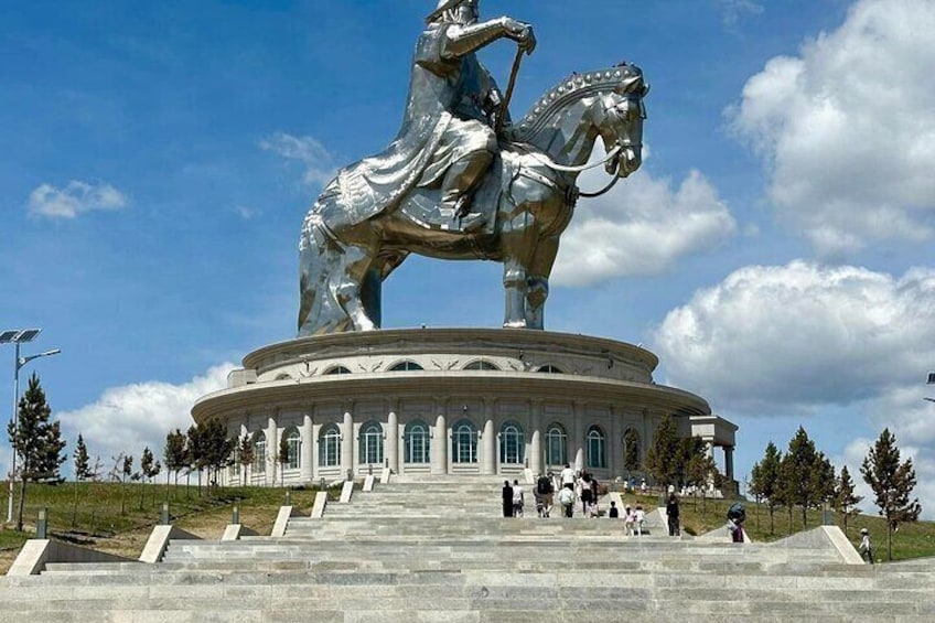 Une grande statue équestre, posée sur un piédestal circulaire accessible par des marches, entourée d’arbres et sous un ciel dégagé. 4