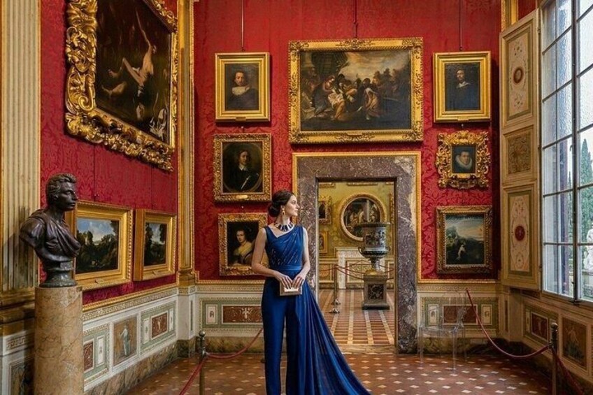 A grand room with red walls, gold-framed paintings, and a marble floor. 5