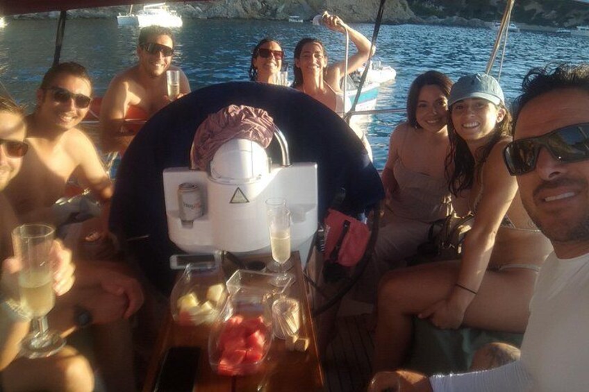A group of people on a boat with drinks and a cooler. 2