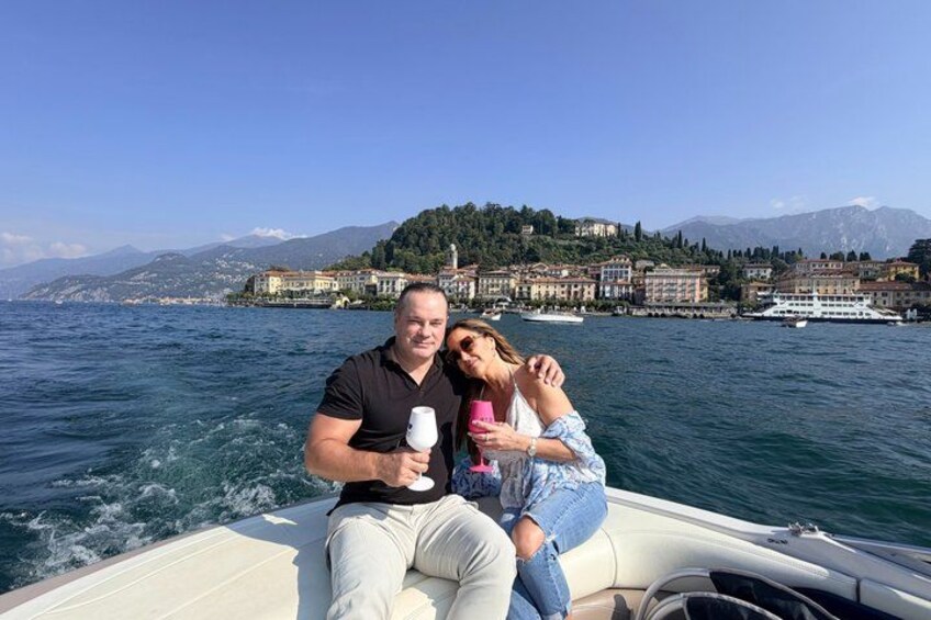 A boat on a lake with a mountainous backdrop and buildings on the shore. 3