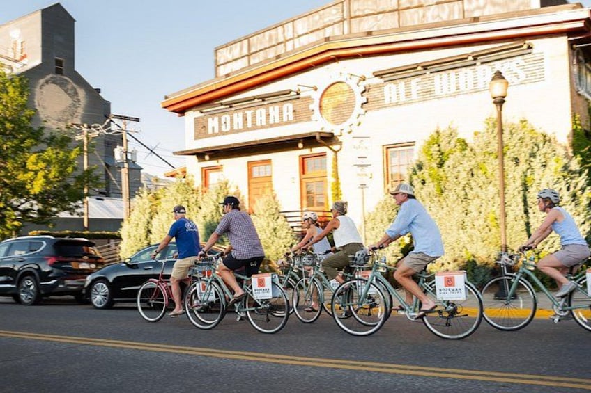 Une rue où l’on voit des cyclistes, un bâtiment sur lequel on peut lire l’inscription « MONTANA », et un beffroi. 5