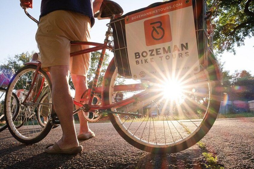 A red bicycle with a basket and a sun shining behind it. 5