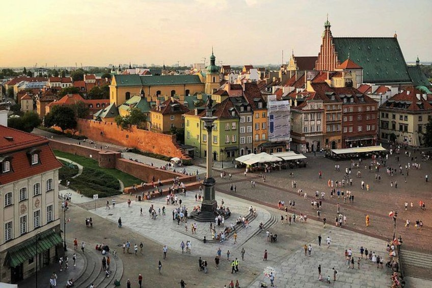 A historic square with a central monument, surrounded by colorful buildings and a large open space. 1