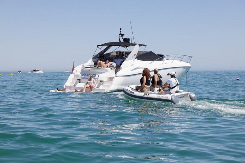 A white motorboat with passengers on the water. 4