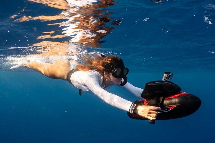 A person underwater, wearing a snorkel and fins, holding a camera. 2