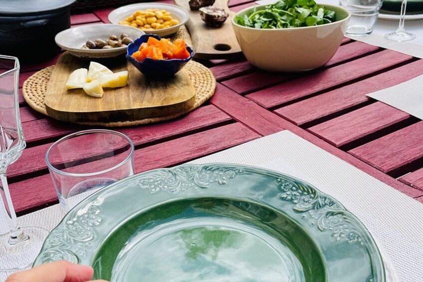 A table with a green plate, bowls of food, and glasses. 2