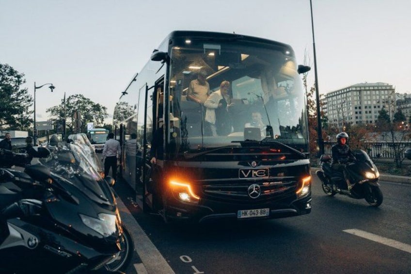 A black bus with the license plate HK-043-BB driving on a road with a motorcyclist in the background. 4