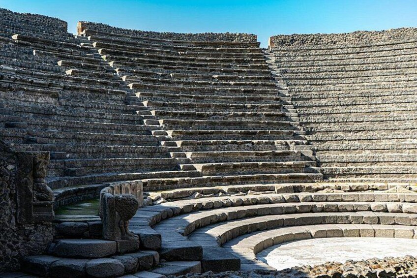 Un amphithéâtre antique doté de gradins en pierre et d’une scène centrale. 3