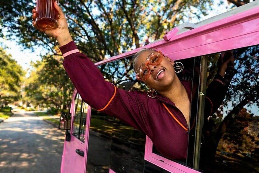 A person in a pink vehicle, holding a drink. 1