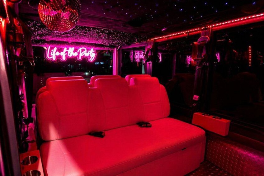 A red-lit room with a neon sign reading 'Life of the Party' and a disco ball. 5