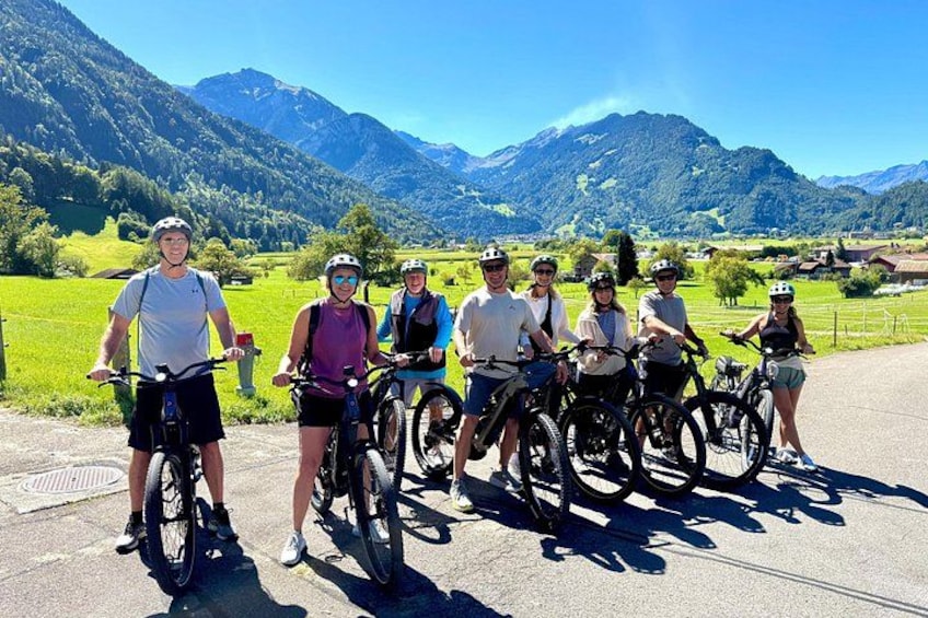 Cycling group photo with mountain valley views on Interlaken E-bike Tour 1