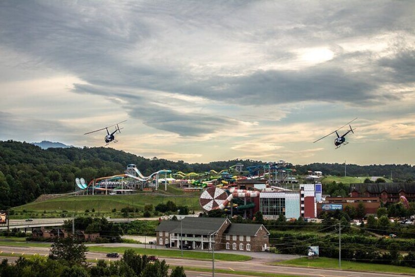 En rutsjebane, en bygning og en helikopter i en park. 3