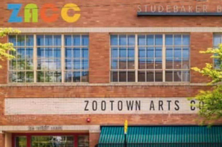 A brick building with large windows and a sign that reads 'ZOOTOWN ARTS CO.' 4