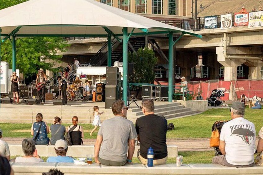 A band performing on stage with an audience seated in front. 5