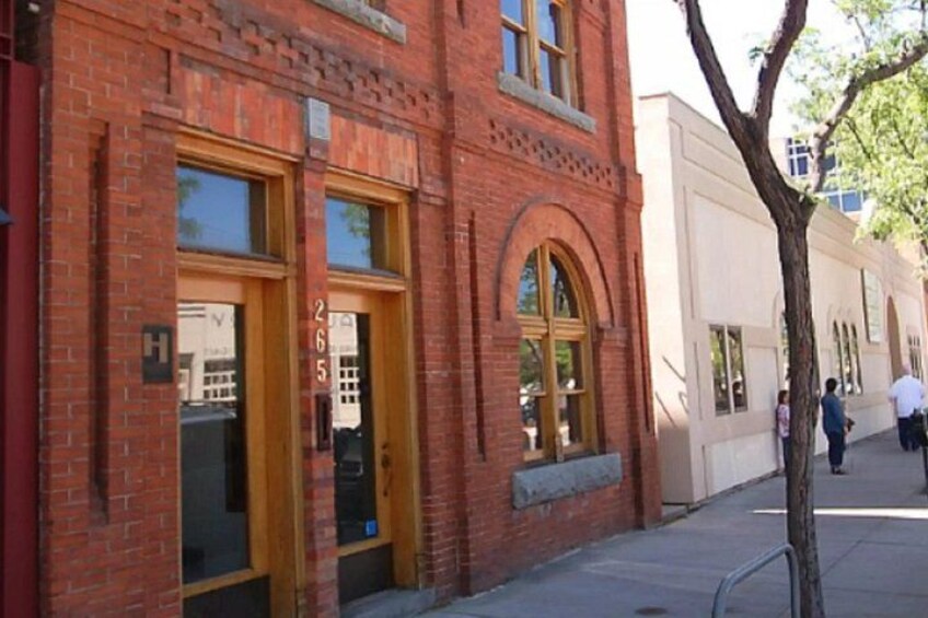 A red brick building with arched windows and a tree in front. 3