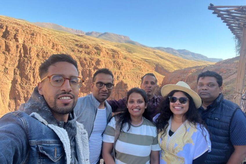A group of people standing in a mountainous area with rocky terrain and a clear sky. 2