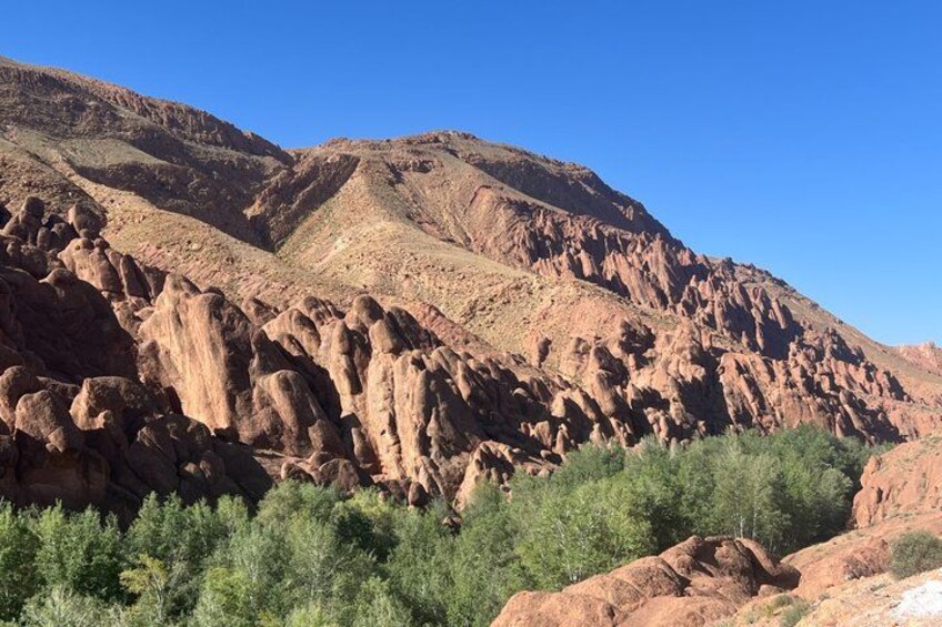 A rugged mountain landscape with rocky formations and sparse vegetation. 3