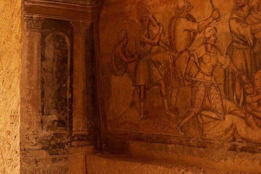 A fresco with figures in historical attire, a doorway, and a wall with a textured surface. 2