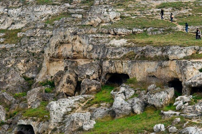 A rocky landscape with large boulders and a grassy area. 5