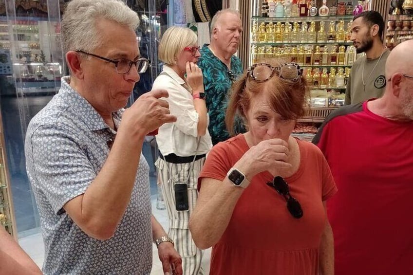 Mensen in een winkel met flessen op rekken. 5