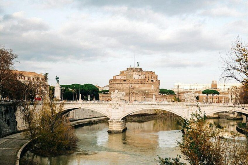 Un río con puentes, un gran edificio histórico y árboles. 4