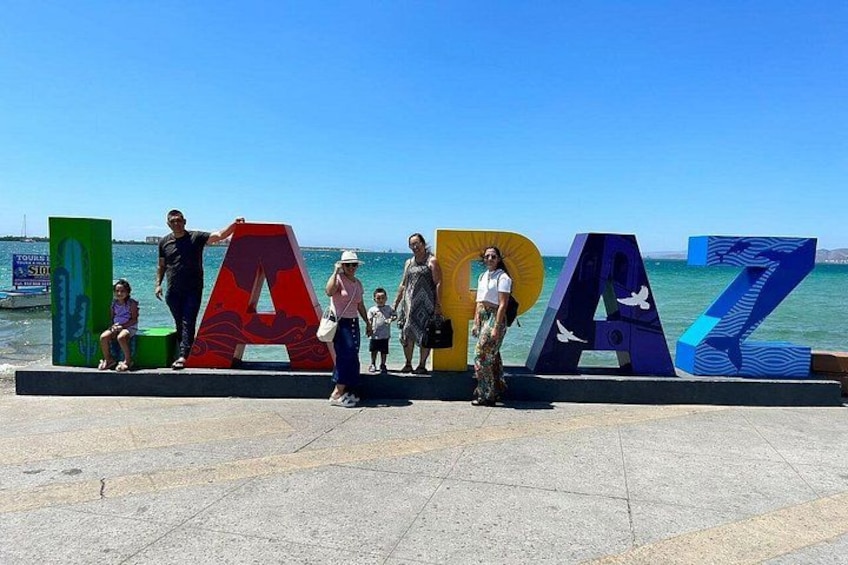 A group of people standing in front of colorful letters spelling 'LAZ.' 4