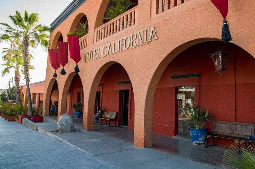 A building with arched entrances and a sign that reads 'HOTEL CALIFORNIA.' 2
