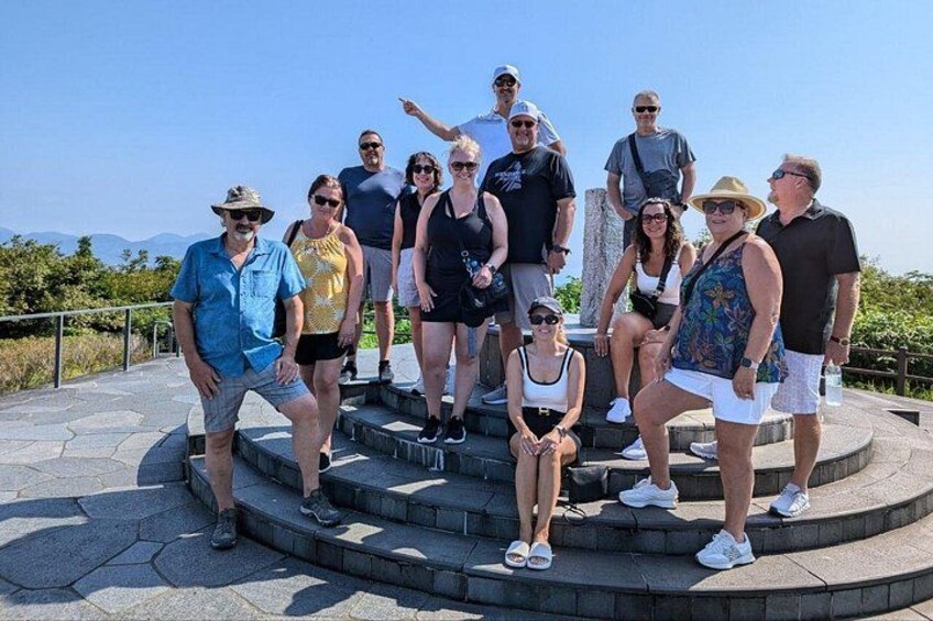 A group of people on a stone staircase with a clear sky in the background. 4