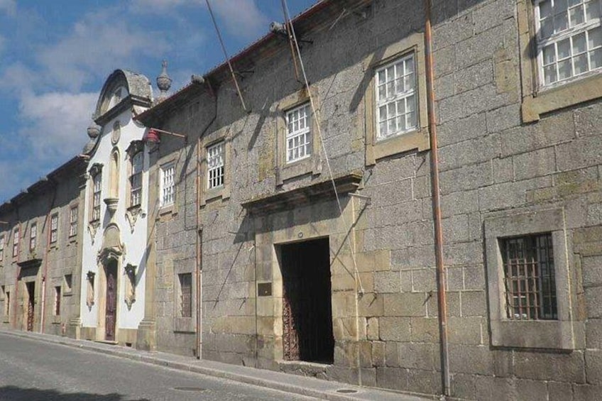 A row of historic stone buildings with arched doorways and windows. 2
