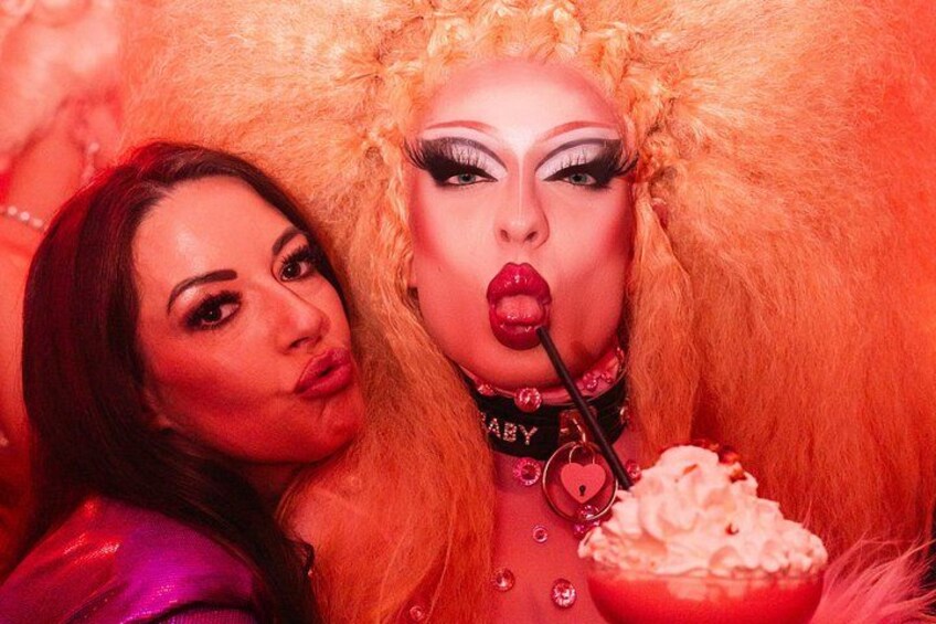 Two individuals with makeup and wigs, one holding a bowl of whipped cream. 3