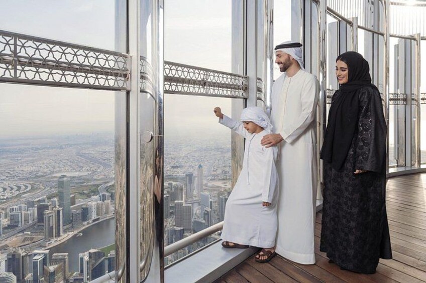 Eine Familie auf dem Balkon eines Hochhauses mit Blick auf eine Stadtlandschaft. 3