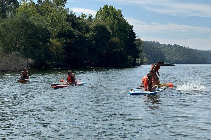 People kayaking on a calm lake surrounded by dense trees. 3