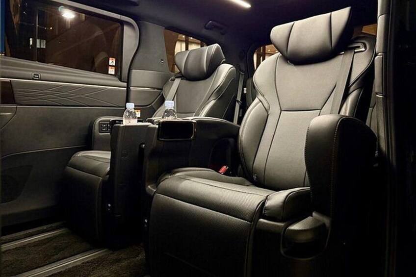 A luxurious car interior with leather seats, a center console, and a cup holder. 3