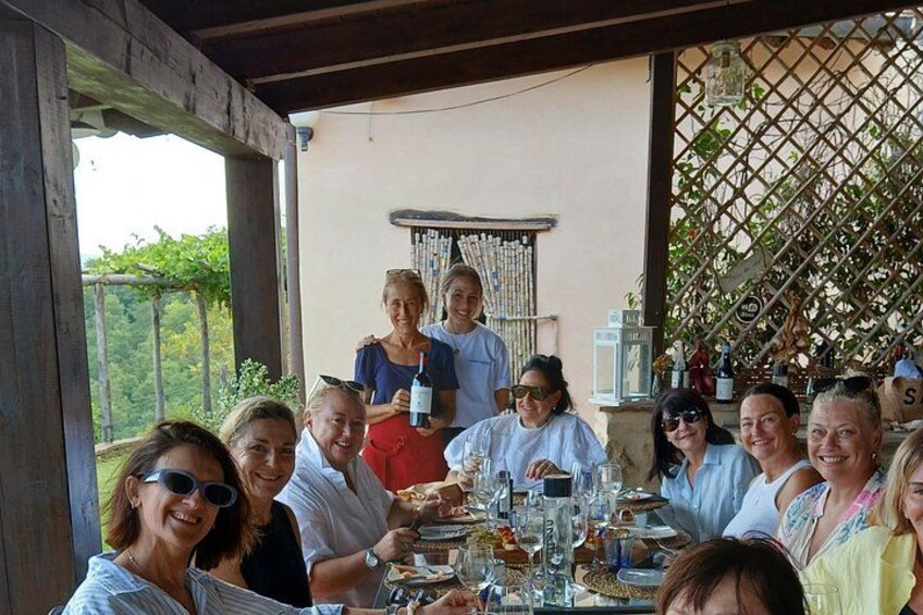 A group of people dining outdoors at a restaurant with a wine rack and outdoor seating. 4