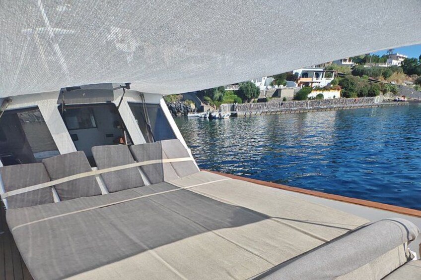 A boat deck with seating and a view of a coastal town. 5