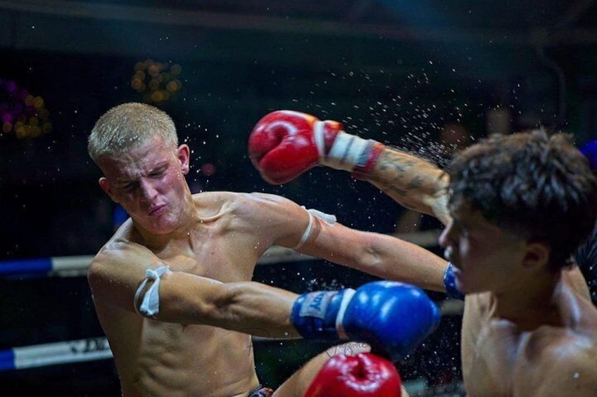 A boxing match with two fighters in red and blue gloves. 1